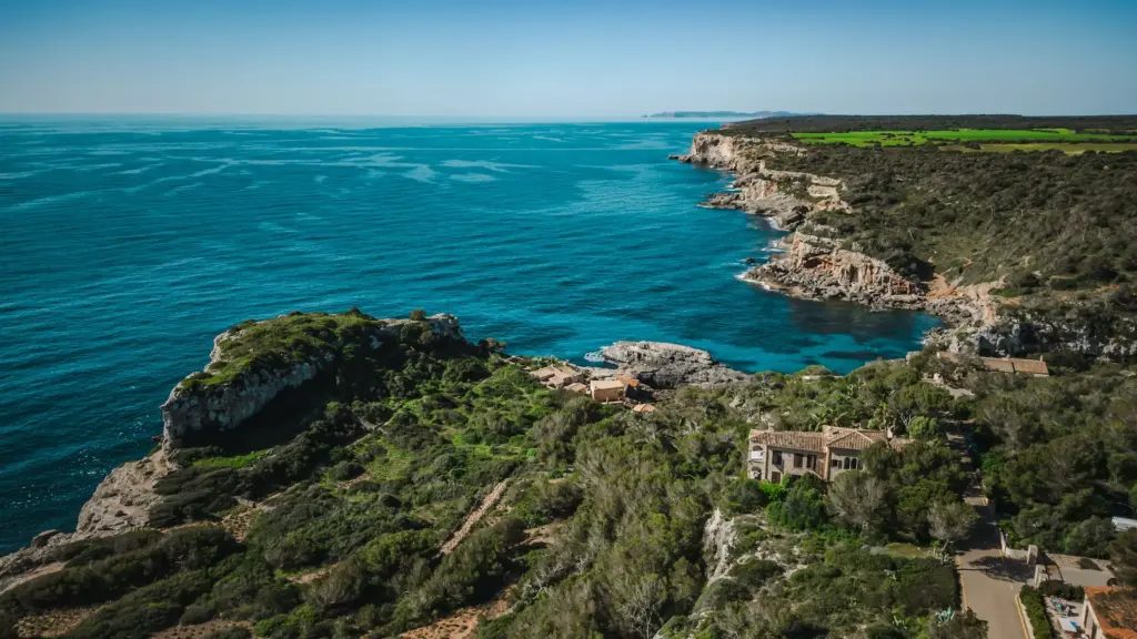 Boat approaching a deep water soloing sector along the coast of Mallorca